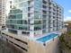 A modern apartment building with a pool and sleek balconies and outdoor seating at 101 S Eola Dr # 1001, Orlando, FL 32801