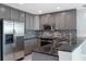 Modern kitchen with stainless steel appliances, gray cabinetry, granite countertops, and tile backsplash at 101 S Eola Dr # 1001, Orlando, FL 32801