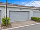 Attached gray two-car garage with paved brick driveway and manicured landscaping at 10426 Folly Beach Rd, Orlando, FL 32827