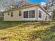 A portion of the backyard with the rear of the house, a small garden and foliage at 1121 Magnolia Blossom Ct, Apopka, FL 32712