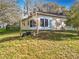 A portion of the backyard with the rear of the house, a small garden and foliage at 1121 Magnolia Blossom Ct, Apopka, FL 32712