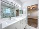 Bathroom showcasing a double vanity, white cabinets, marble floors, and a frameless glass shower at 1121 Magnolia Blossom Ct, Apopka, FL 32712