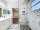 Bathroom showcasing a double vanity, white cabinets, marble floors, and glass shower at 1121 Magnolia Blossom Ct, Apopka, FL 32712