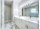 Bathroom showcasing a double vanity, white cabinets, marble floors, and a frameless glass shower at 1121 Magnolia Blossom Ct, Apopka, FL 32712