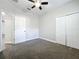 Bright bedroom features soft gray carpet, ceiling fan, and a large closet for ample storage at 1121 Magnolia Blossom Ct, Apopka, FL 32712