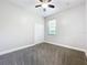 Well-lit bedroom with gray carpet, ceiling fan, window, and a closet with folding doors at 1121 Magnolia Blossom Ct, Apopka, FL 32712