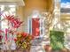 Close up of a red front door with sidelights and colorful landscaping in front of home at 1121 Magnolia Blossom Ct, Apopka, FL 32712