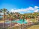 Resort-style pool area with palm trees, lounge chairs, and beautiful landscaping offers relaxation at 1121 Magnolia Blossom Ct, Apopka, FL 32712