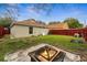 Backyard featuring a large grassy area with a fire pit and mature trees at 1201 City Park Ave, Orlando, FL 32808