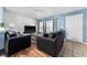 Bright living room featuring tile flooring, a ceiling fan, and natural light from large windows at 1201 City Park Ave, Orlando, FL 32808