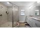 Bathroom with granite countertop, double sinks, white cabinets, and glass shower at 149 E Muriel St, Orlando, FL 32806