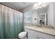 Bright bathroom featuring granite countertop, white cabinets, toilet, and shower with a blue curtain at 149 E Muriel St, Orlando, FL 32806