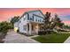 Charming two-story home with a inviting front porch and beautifully landscaped front yard at dusk at 149 E Muriel St, Orlando, FL 32806
