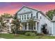 Charming two-story home with a inviting front porch and beautifully landscaped front yard at dusk at 149 E Muriel St, Orlando, FL 32806