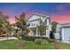 Charming two-story home with a inviting front porch and beautifully landscaped front yard at dusk at 149 E Muriel St, Orlando, FL 32806