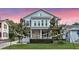 Charming two-story home featuring a inviting front porch and beautifully landscaped front yard at dusk at 149 E Muriel St, Orlando, FL 32806
