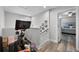 Bright hallway leads to a bedroom with a blue bed, Peloton bike, and Gathering photos on the wall at 149 E Muriel St, Orlando, FL 32806