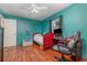 Bedroom with light wood floors, a ceiling fan, a window, and an office chair by the desk at 1503 Wisconsin Ave, St Cloud, FL 34769