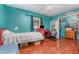 Bedroom with light wood floors, a ceiling fan, a window and closet with hanging clothes and shelves at 1503 Wisconsin Ave, St Cloud, FL 34769