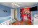 Bedroom featuring blue walls, a ceiling fan, and an opened closet with decorations and storage shelves at 1503 Wisconsin Ave, St Cloud, FL 34769