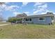 Home exterior showing the front yard with mature landscaping and covered front porch at 1503 Wisconsin Ave, St Cloud, FL 34769