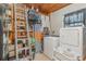 Laundry room featuring a washer, dryer, shelving, and a ladder against the wall at 1503 Wisconsin Ave, St Cloud, FL 34769