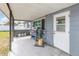 Covered patio featuring grey sidings, propane tanks, a grill, and a door leading to the interior at 1503 Wisconsin Ave, St Cloud, FL 34769