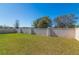 A well-manicured backyard featuring a privacy fence and a lush green lawn with mature trees in the background at 1546 Park Leah Cir, Apopka, FL 32712