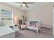 Bright bedroom with a window, crib, chair, and ' furniture set at 1546 Park Leah Cir, Apopka, FL 32712