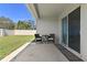 Covered patio with table and chairs situated outside the sliding glass doors leading to backyard at 1546 Park Leah Cir, Apopka, FL 32712