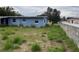 A view of the home's backyard and a partially viewed fenced area, and overgrown vegetation at 1606 26Th St, Orlando, FL 32805