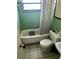 Picture of a bathroom with a green tile wall, toilet, tub, and shower curtain at 1606 26Th St, Orlando, FL 32805