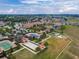 Aerial view featuring the community's clubhouse, swimming pool, tennis courts and surrounding landscape at 172 Balmy Coast Rd, Groveland, FL 34736