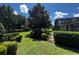 Serene backyard featuring a screened-in lanai, mature trees, and manicured landscaping, creating a private outdoor oasis at 172 Balmy Coast Rd, Groveland, FL 34736