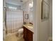 Bright bathroom featuring a granite vanity, framed mirror, and a shower with a patterned curtain at 172 Balmy Coast Rd, Groveland, FL 34736