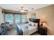 Relaxing bedroom with large windows, a ceiling fan, and neutral decor, creating a tranquil retreat at 172 Balmy Coast Rd, Groveland, FL 34736