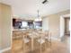 This staged dining room features a chandelier and a wooden table and chairs, opening up to the kitchen at 172 Balmy Coast Rd, Groveland, FL 34736