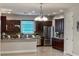 This kitchen has stainless steel appliances, dark wood cabinets, and a granite countertop with barstool seating at 172 Balmy Coast Rd, Groveland, FL 34736