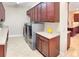 Laundry room with front load washer and dryer, granite countertops, and brown cabinetry at 172 Balmy Coast Rd, Groveland, FL 34736