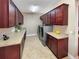 Laundry room with front load washer and dryer, granite countertops, and brown cabinetry at 172 Balmy Coast Rd, Groveland, FL 34736