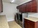 This laundry room features side-by-side washer and dryer, upper and lower cabinets and granite countertops at 172 Balmy Coast Rd, Groveland, FL 34736