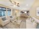 This staged living room opens to the kitchen and dining room and features a ceiling fan and arm chairs at 172 Balmy Coast Rd, Groveland, FL 34736
