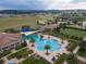 Aerial view of a community pool with lounge chairs, cabanas, and landscaped grounds at 172 Balmy Coast Rd, Groveland, FL 34736