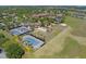 Aerial view of community with tennis courts, bocce ball, clubhouse, and landscaping at 172 Balmy Coast Rd, Groveland, FL 34736