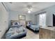 Well-lit bedroom features twin beds, a ceiling fan, and a modern dresser at 1739 Nectarine Trl, Clermont, FL 34714