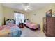 Charming bedroom showcasing twin beds with themed bedding, wood furniture, and a TV at 1739 Nectarine Trl, Clermont, FL 34714