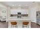 Modern kitchen with white cabinetry, stainless steel appliances, a large island, and stylish backsplash at 2041 Lobelia Dr, Lake Mary, FL 32746