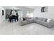 Bright and airy living room features modern tile flooring, a large gray sofa, and plenty of natural light at 2229 Churchill Downs Cir, Orlando, FL 32825