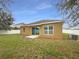 A spacious backyard with a sliding glass door leading to a patio, enhanced by a secure white fence at 240 Whispering Pines Way, Davenport, FL 33837