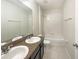 Clean bathroom featuring double sinks, granite countertops, and a shower over tub at 240 Whispering Pines Way, Davenport, FL 33837